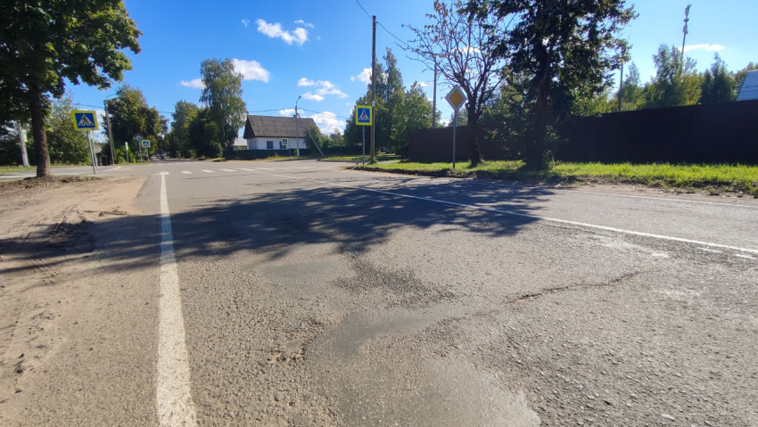 Низкий ракурс на асфальт у перекрёстка со знаками пешеходного перехода
