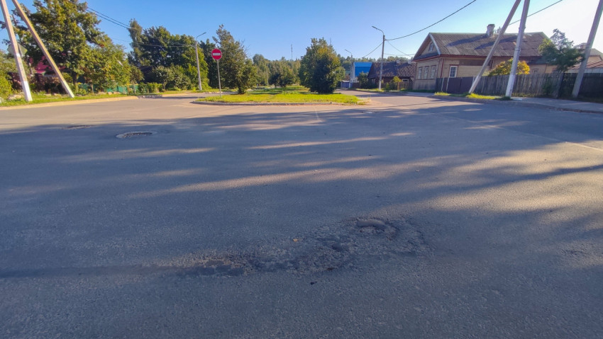 Перекрёсток в жилом районе с дорожными знаками и зелёным островком