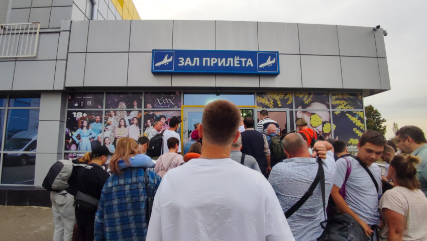Вход в зал прилёта с вывеской «ЗАЛ ПРИЛЁТА» и толпой пассажиров