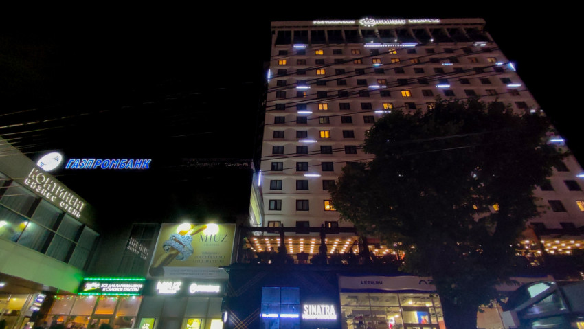 Высотное здание с вывесками Gazprombank и LETU.RU в ночном городе