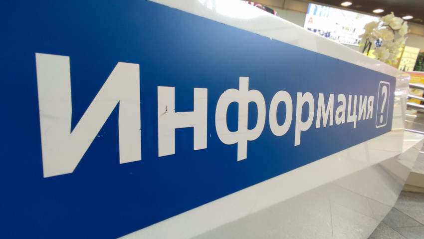 Надпись «Информация» на стойке, фон терминала мягко размывается