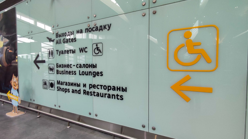 Указатели на стеклянной стене: выходы на посадку, туалеты и бизнес-залы