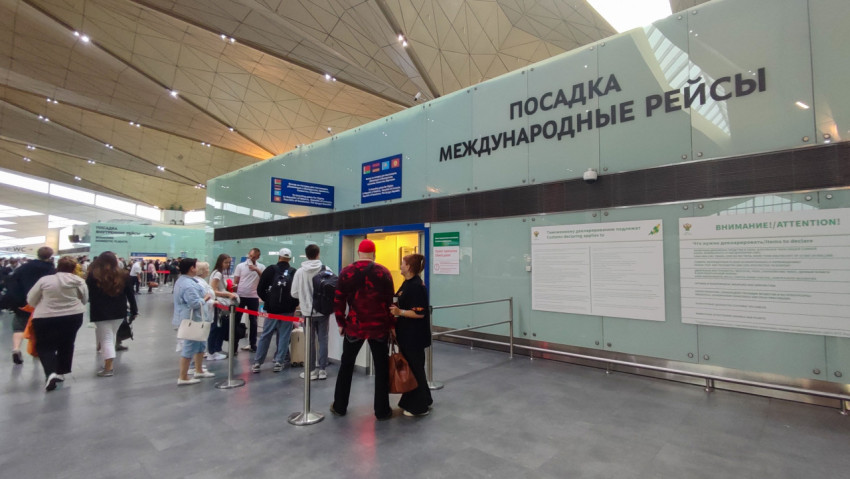 Общий зал у международной посадки: поток людей и вход с лентой