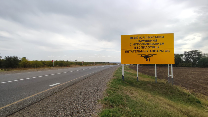 Дорожный щит о фиксации нарушений ПДД с беспилотника на пустынном участке трассы
