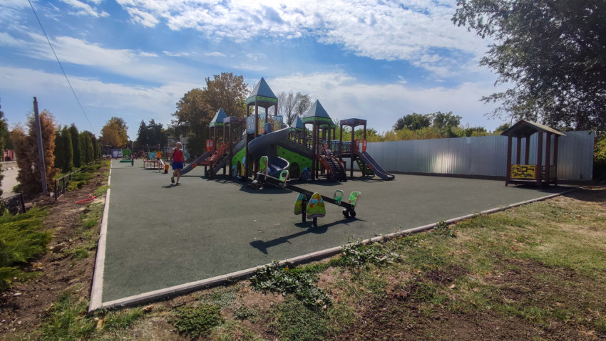 Игровая зона на резиновом покрытии рядом с посёлковой улицей