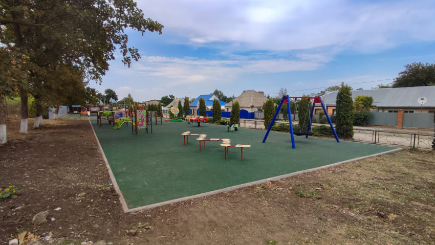 Панорама детской площадки с качелями и резиновым настилом