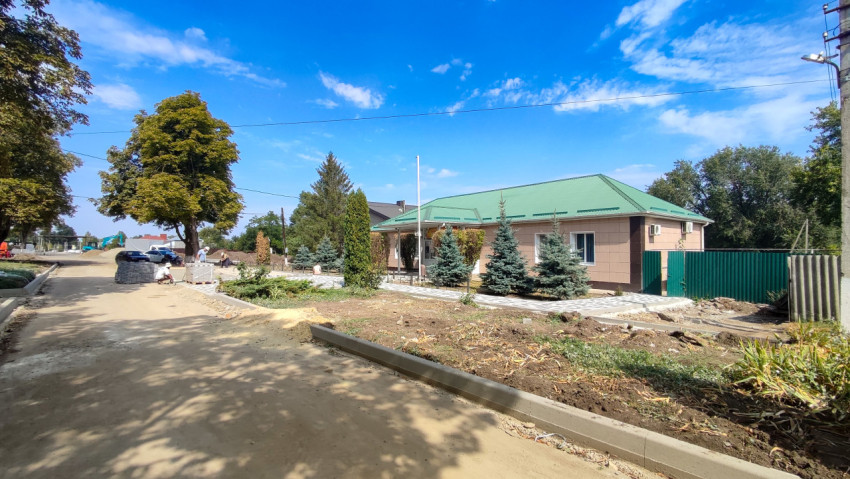 Благоустройство сельской улицы: новые бордюры, щебень и штабели плитки