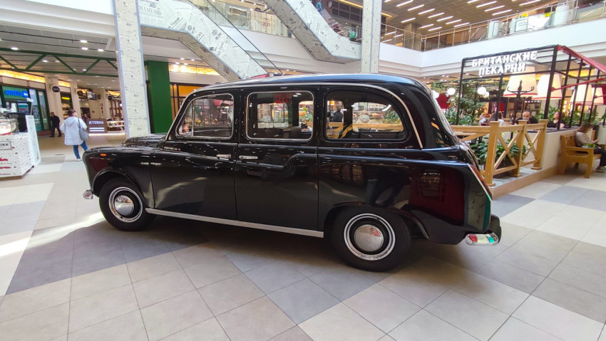 Вид на ретро-такси Austin FX4 сбоку в помещении торгового центра