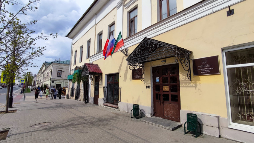Здание комитета ЖКХ с флагами на улице в центре Казани