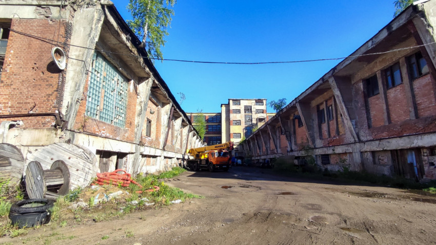Двор заброшенного завода с грузовой техникой