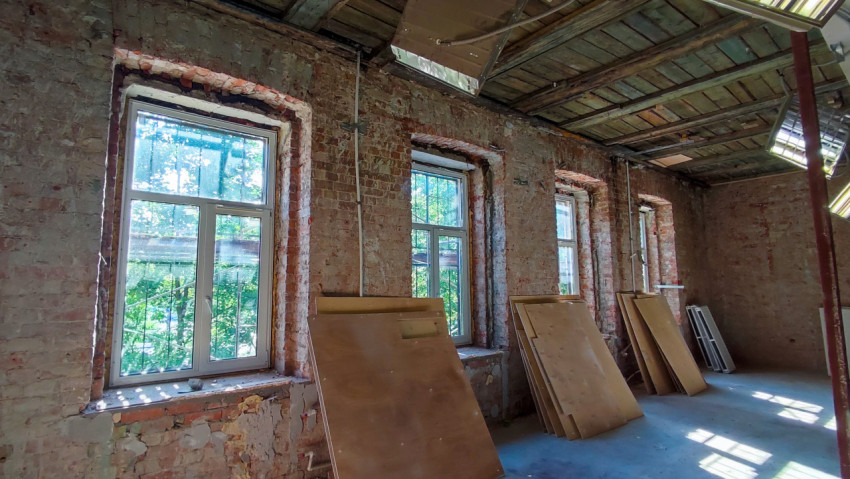 Кирпичные стены и окна с пластиковыми рамами в процессе ремонта