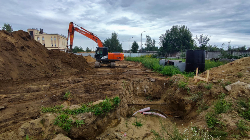 Экскаватор на строительной площадке у котлована