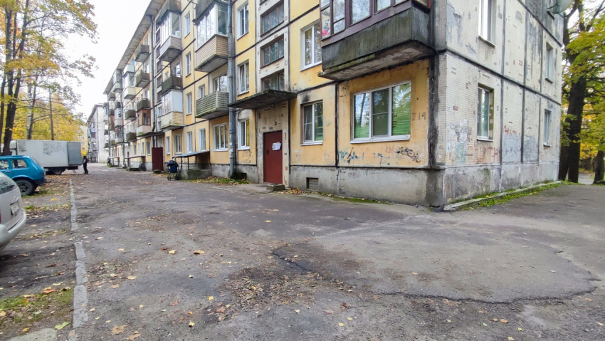 Фасад жилого дома с балконами и асфальтовым двором