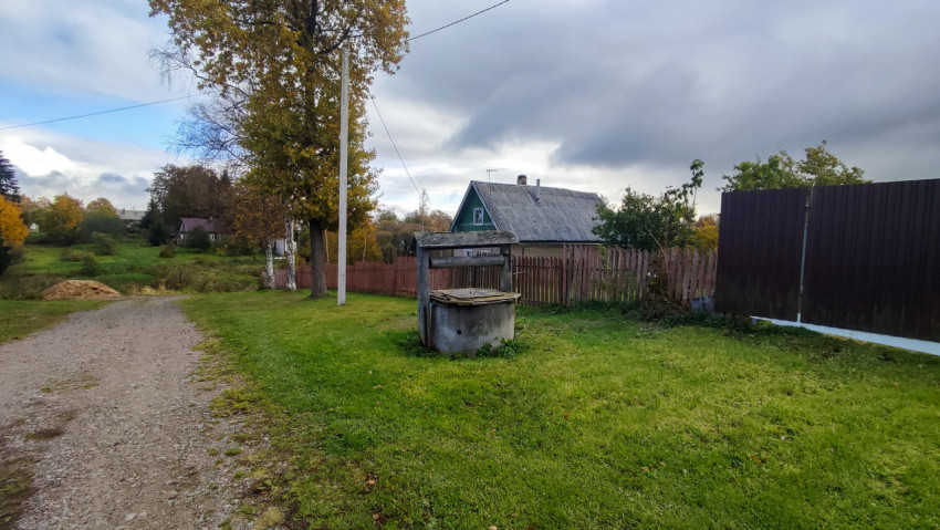 Колодец у сельской дороги на фоне осеннего пейзажа