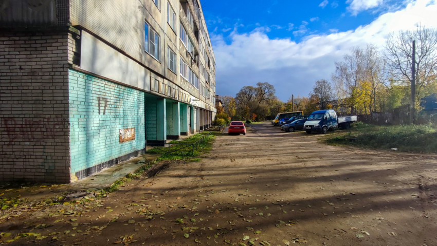 Торцевая часть жилого дома и дворовая парковка