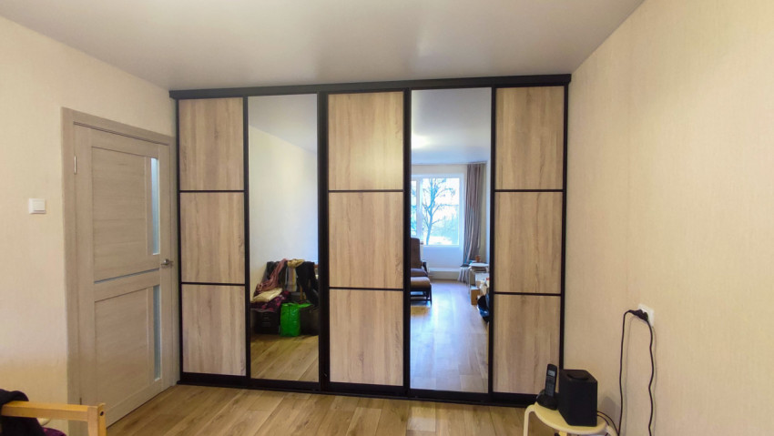 Современный интерьер жилой комнаты с зеркальным шкафом-купе