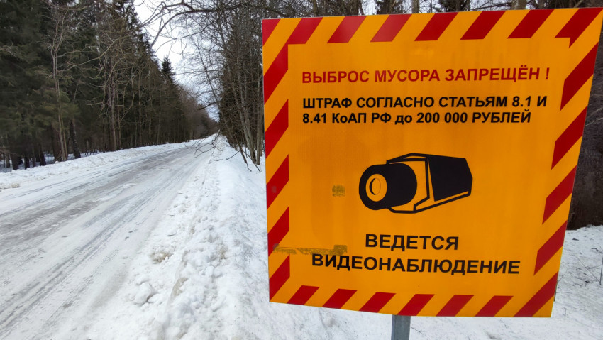 Знак «Выброс мусора запрещён» на обочине зимней дороги