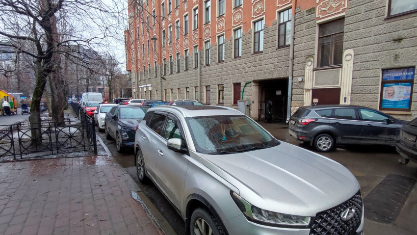 Ряд автомобилей у фасада исторического дома