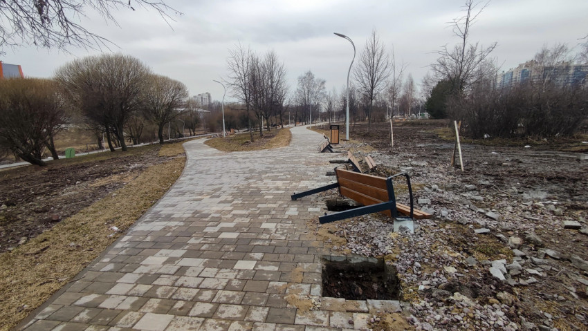 Городской парк с недоустановленными скамейками на пешеходной дорожке