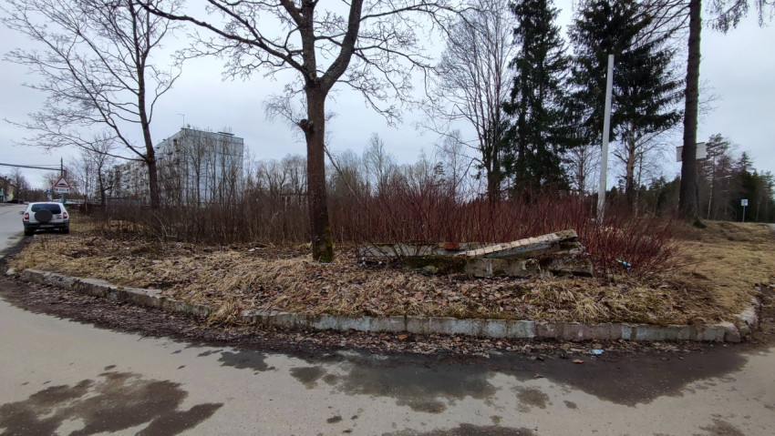 Поворот дороги у заросшего пустыря и припаркованного автомобиля