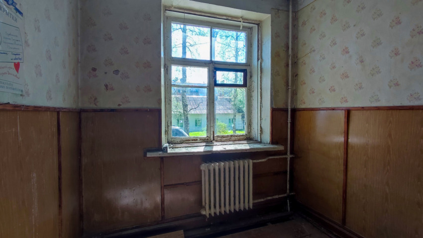 Комната с окном и радиатором в старом здании