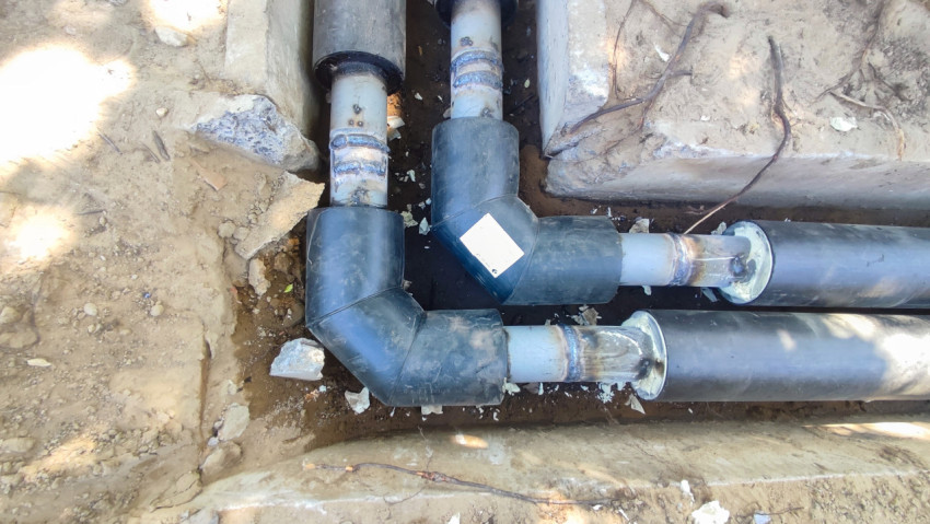 Сварные стыки трубопровода с поворотами в бетонном канале, вид сверху