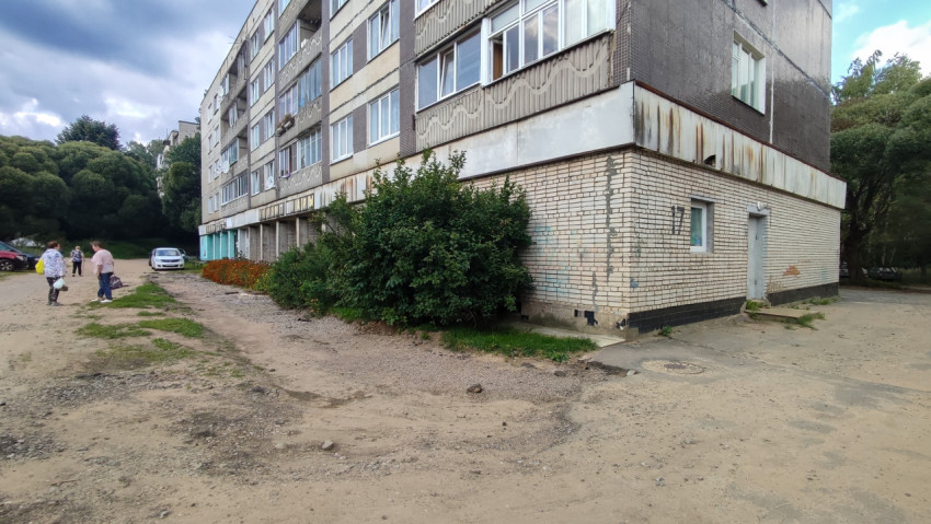 Въезд во двор у подъезда с разбитым асфальтом и участком щебня