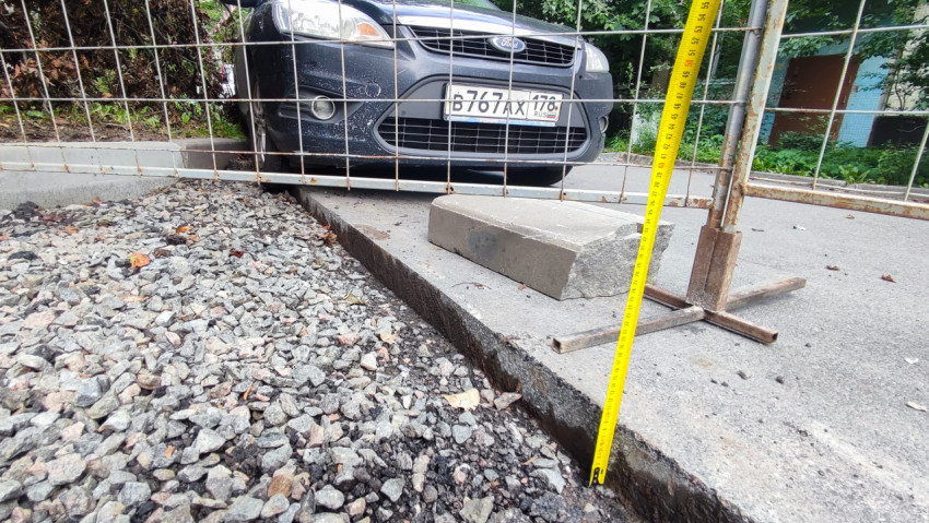 Измерение рулеткой у кромки асфальта и бордюра на участке ремонта