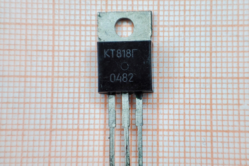 Транзистор КТ818Г на фоне миллиметровой бумаги