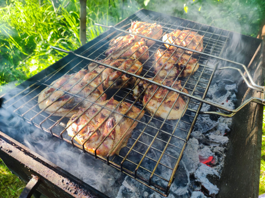 Курица на решётке-гриль над углями в мангале, крупный план