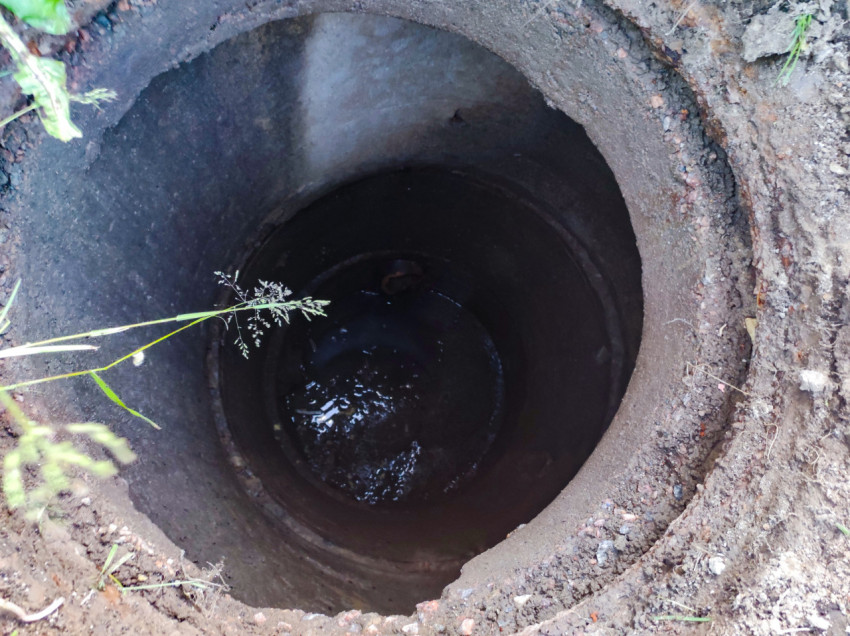 Внутренний вид бетонного колодца с водой на дне, снятый сверху