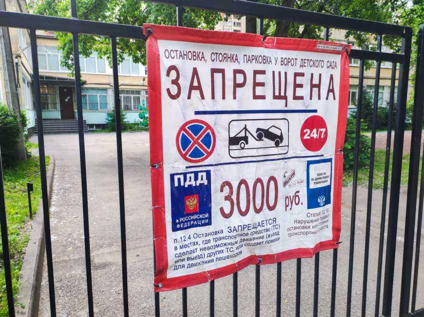 Баннер «Запрещена» о запрете остановки и парковки у ворот детского сада, крупный план