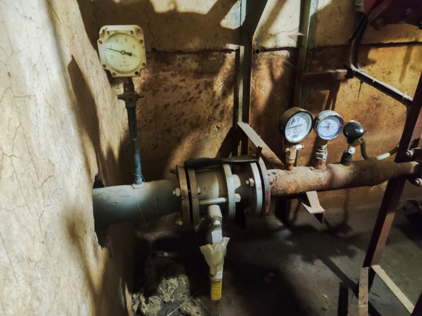 Манометры и фланцевое соединение на трубопроводе у ввода в стену технического помещения