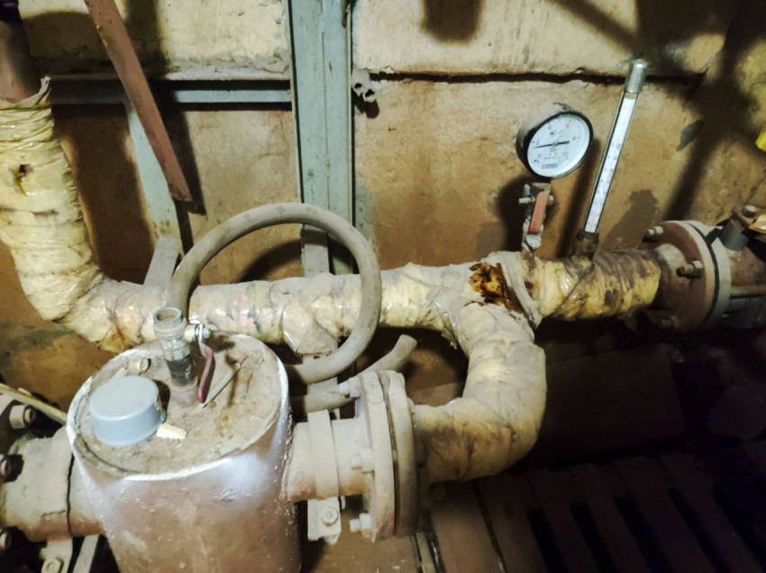 Манометр и термометр на утеплённом трубопроводе крупным планом