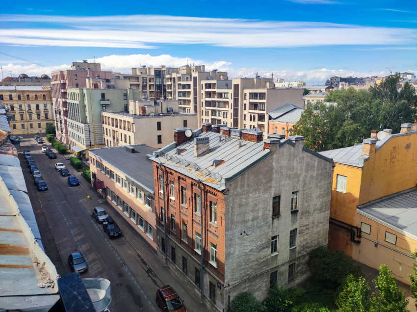 Городской квартал с улицей, кирпичным домом и современными жилыми корпусами