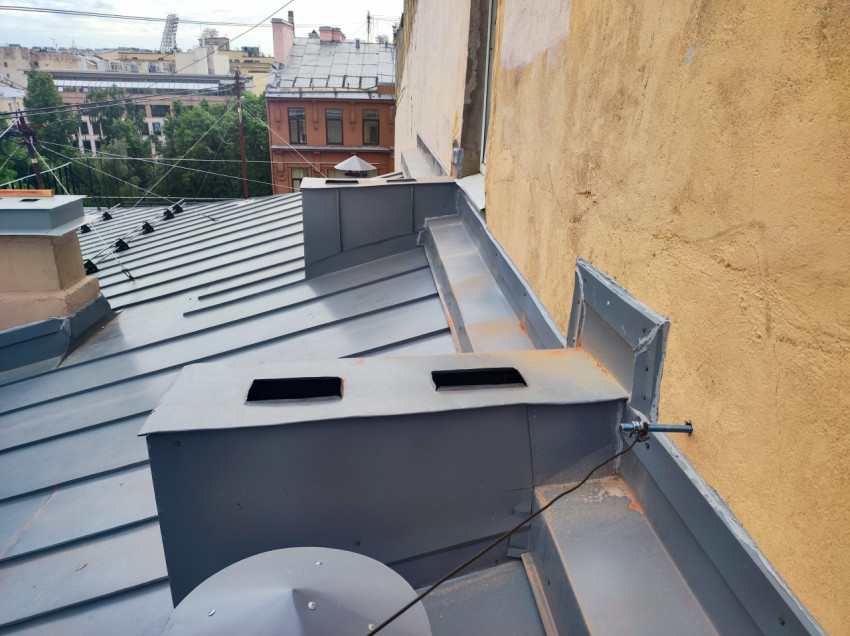 Кровля у фасадной стены с коробами вентиляции и проводкой над двором