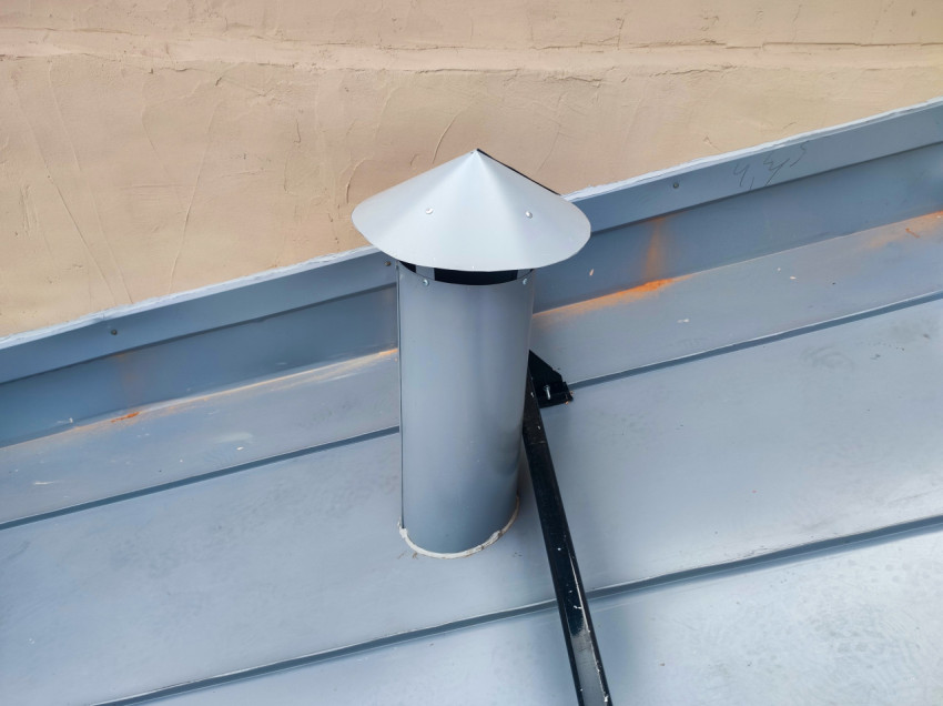 Вентиляционная труба с защитным колпаком на фальцевой металлической крыше