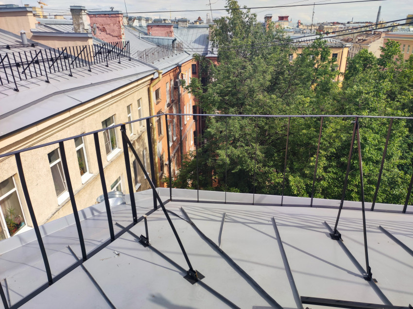 Кровля с ограждением и видом во двор-колодец с деревом и фасадами домов