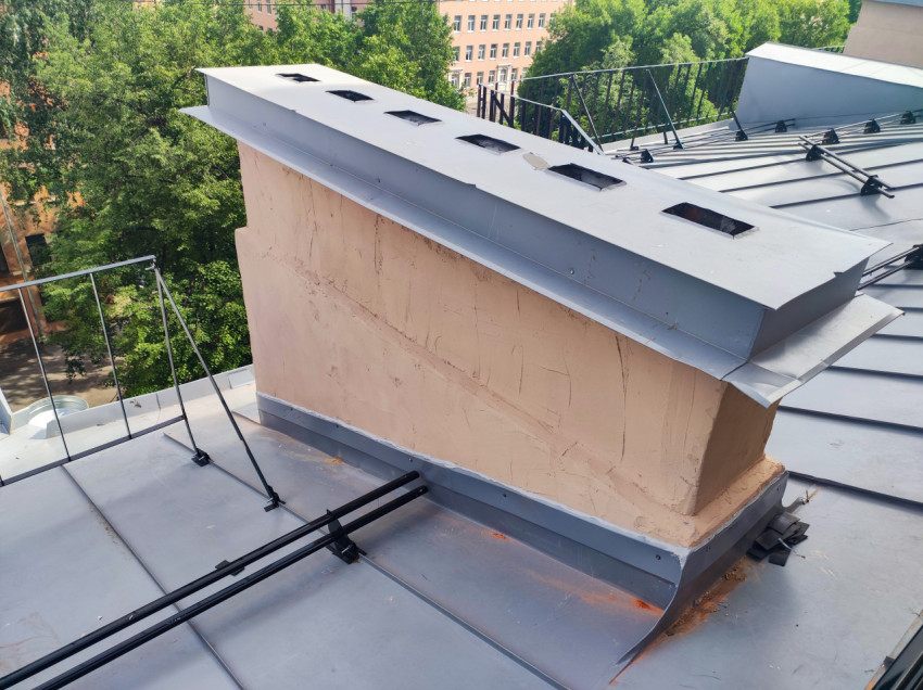 Вентиляционная шахта на металлической крыше с защитным козырьком