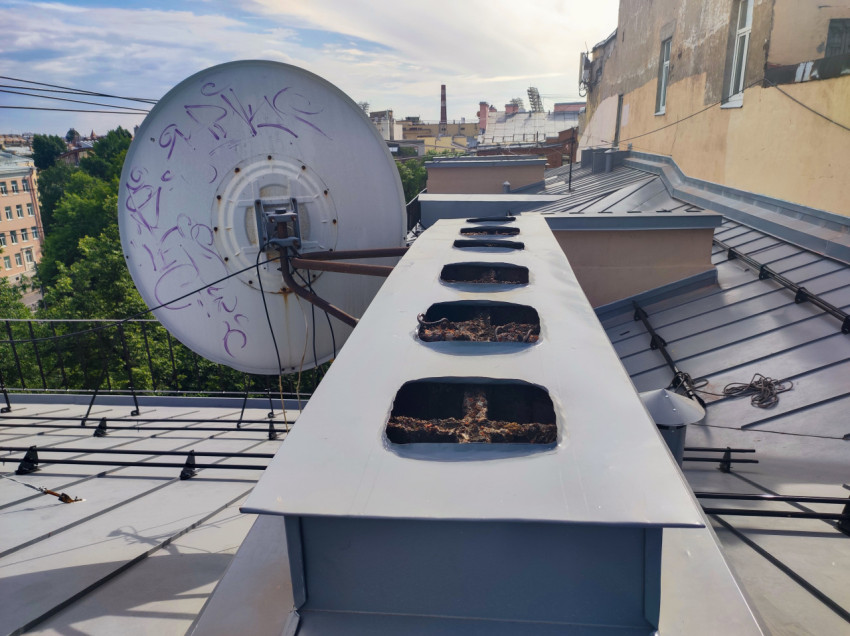 Спутниковая антенна и вентиляционный короб на крыше жилого дома