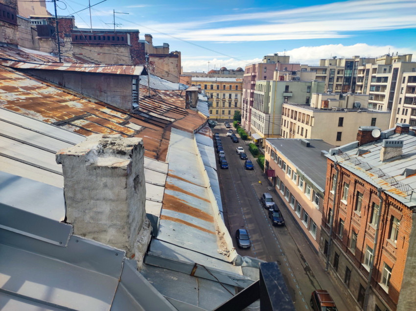 Вид с крыши на улицу и квартал с контрастом старых и новых зданий