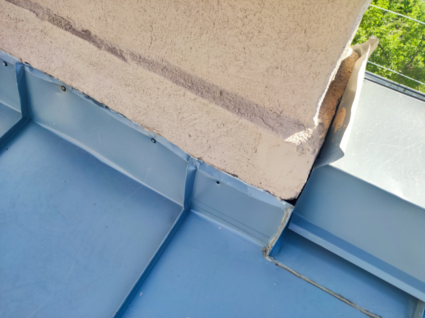 Узел примыкания оштукатуренной стены к металлической кровле с фартуком и герметизированными стыками