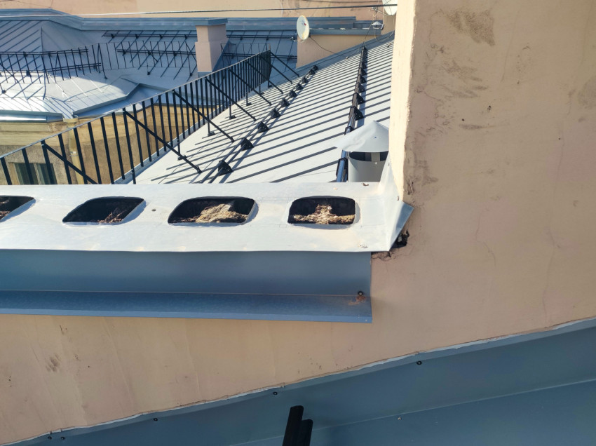 Вентиляционный короб на крыше с отверстиями и снегозадержателями на скате