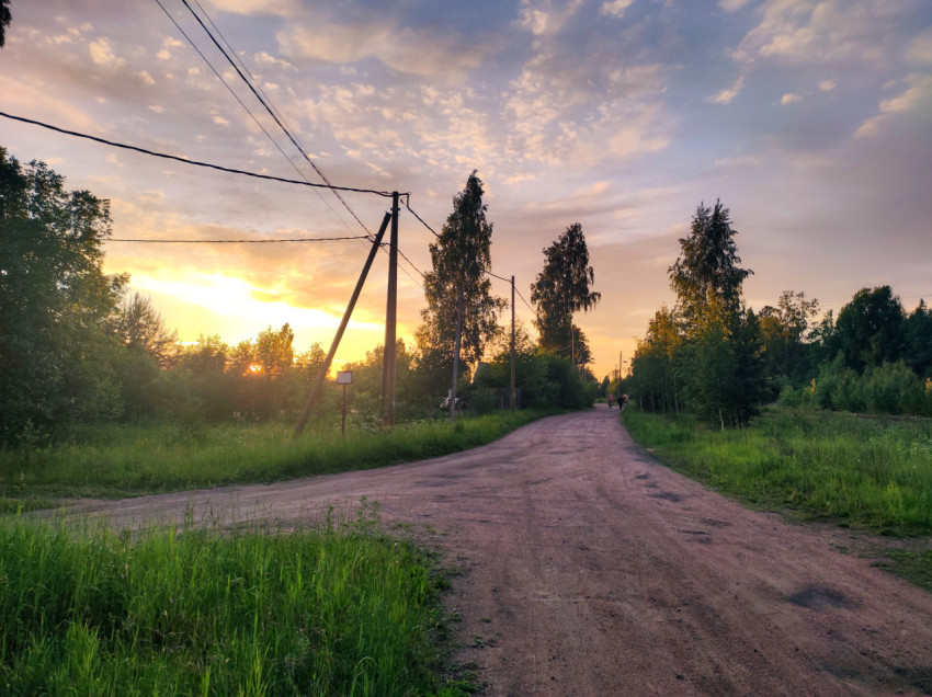 Грунтовая дорога с линией электропередачи на закате в сельской местности