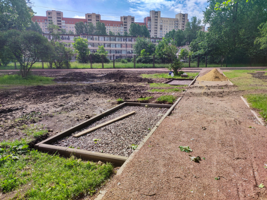 Дворовая дорожка с бордюрами и щебёночными картами рядом с кучей песка