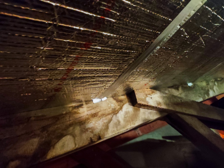 Узел примыкания теплоизоляции к деревянной балке на чердаке, крупный план