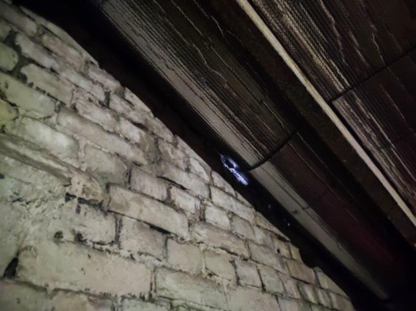 Белая кирпичная кладка и потолочные доски под крышей с зазором для света