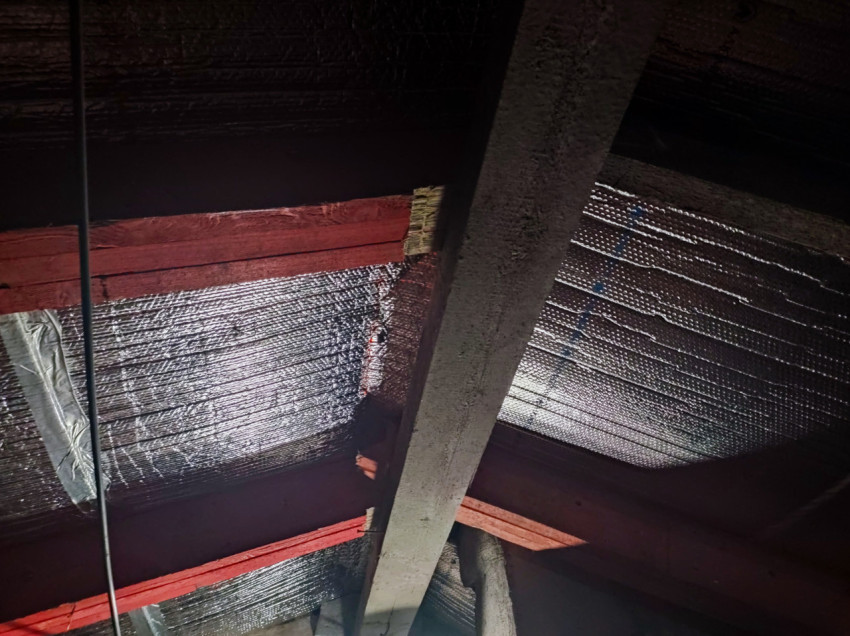 Кровельная конструкция с фольгированным утеплителем, красными балками и кабелем