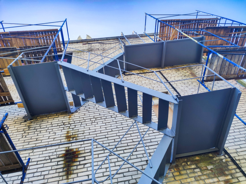 Вид снизу на марш наружной лестницы и площадки в окружении строительных лесов