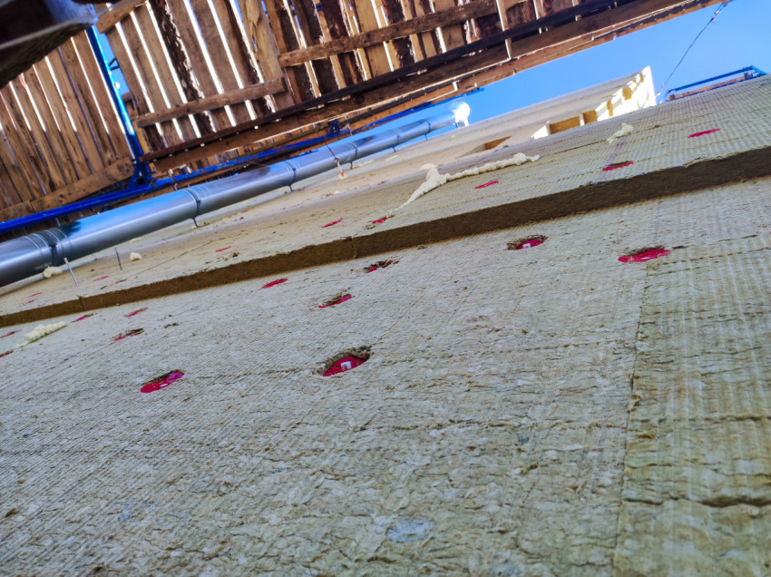 Монтаж плит минераловатного утеплителя с тарельчатыми дюбелями под деревянным настилом строительных лесов